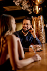 Couple Enjoying Drinks at a Cozy Bar in a Relaxed Atmosphere