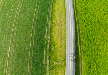 Aerial view of rural road through countryside meadows and farmland in Canton of Fribourg in Switzerland. 