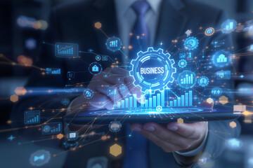 Businessman holding a tablet displaying a glowing digital interface with financial charts and business icons symbolizing innovation and growth