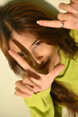 beautiful young woman with hands up. fingers posing.  making click by fingers in camera. smile emotions. joyfull creative