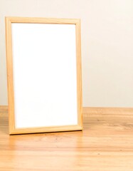 Light wood frame on wooden table, blank white interior