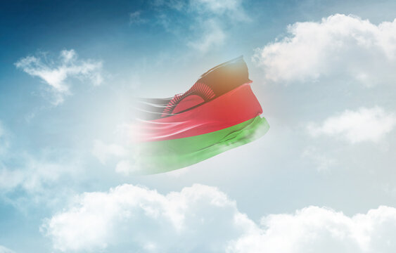 Malawi flag waving light background hidden in the sky.