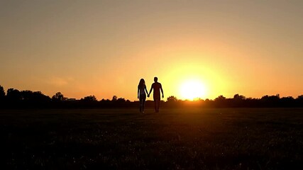 Scenic sunset silhouette of couple walking together outdoors, representing love, bonding, and cinematic lifestyle visuals for storytelling and romance themes.
