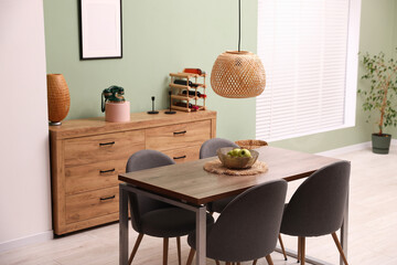 Wooden table with chairs and apples in dining room. Interior design