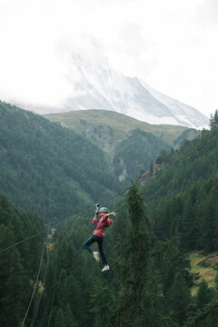 girl doing a zip wire in the mountains in Zermatt Switzerland