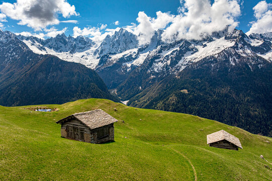 Mountain huts on green alpine meadows