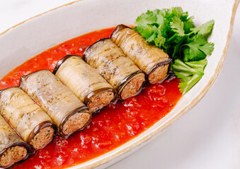 Delicious stuffed eggplant rolls served in rich tomato sauce with herbs