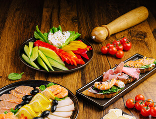A vibrant display of fresh seafood, assorted vegetables, and garnishes on a rustic wooden table. Shrimp, salmon, and colorful veggies create an inviting atmosphere for a delicious meal.
