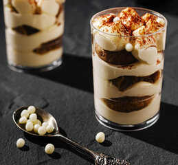 Delicious tiramisu dessert layered with creamy filling and sponge cake in elegant glass