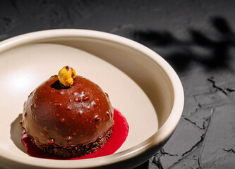Decadent chocolate dessert served with raspberry sauce on elegant plate
