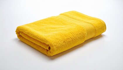 Folded yellow towel on white surface, soft and minimal