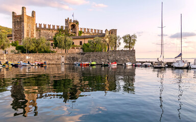 The Scaligero Castle by the small port of Torri del Benaco, Garda lake, Italy. An impressive medieval structure with walls and towers, reflecting its historical significance and architectural style.