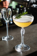 A skilled bartender crafts a vibrant cocktail, garnished with fresh herbs for flavor