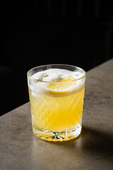 A crisp cocktail with lemon slices invites relaxation and conversation on a rustic bar