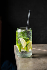 A refreshing drink with lime and mint awaits on a rustic tabletop