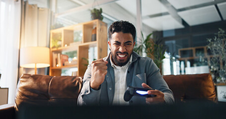 Happy man, winning and game with fist pump for esport, online competition or entertainment in home. Excited, male person and console gamer with controller in celebration for victory or tournament © peopleimages.com