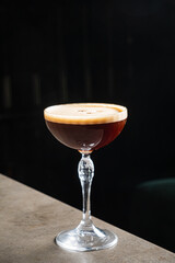 A frothy cocktail in a crystal glass showcases its rich colors and textures