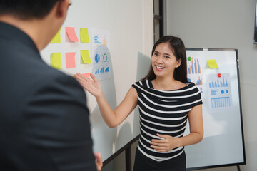 Pregnant businesswoman explaining charts and statistics to her colleague