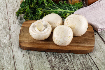 White champignon mushrooms heap over board