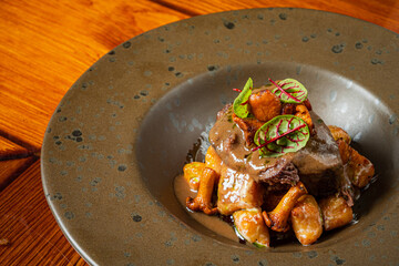 A beautifully presented dish of tender beef served with savory gnocchi and herbs