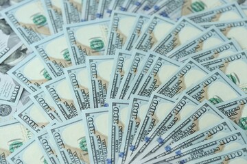 Many hundred dollar bills new banknotes in big pile under the natural light