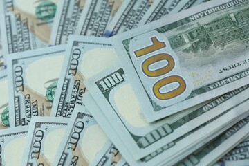 Many hundred dollar bills new banknotes in big pile under the natural light