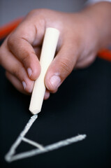 hand writing alphabet a with white chalk on black slate 