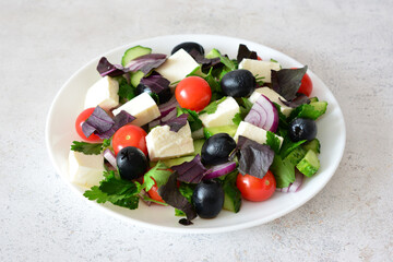 Fresh and Colorful Greek Salad on a White Plate isolated close up