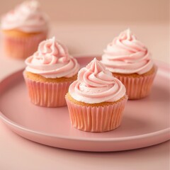 Several cupcakes, filled with strawberry pure and tinted frosting, rest upon a pink plate. Soft, ambient lighting enhances the vibrant pink frosting and delicious-looking cakes