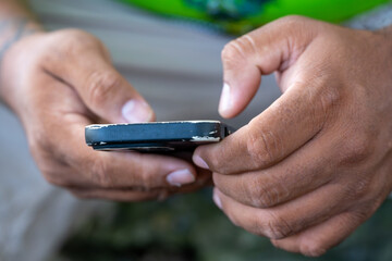 Close-up of hands using a worn mobile phone, suggesting Internet access and communication.