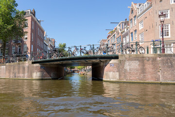 Obraz premium Amsterdam, Netherlands - July 02, 2018: Bridge over the river channel in the center of Amsterdam