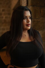 Fototapeta premium Confident Woman in Black Outfit Posing Indoors by Window