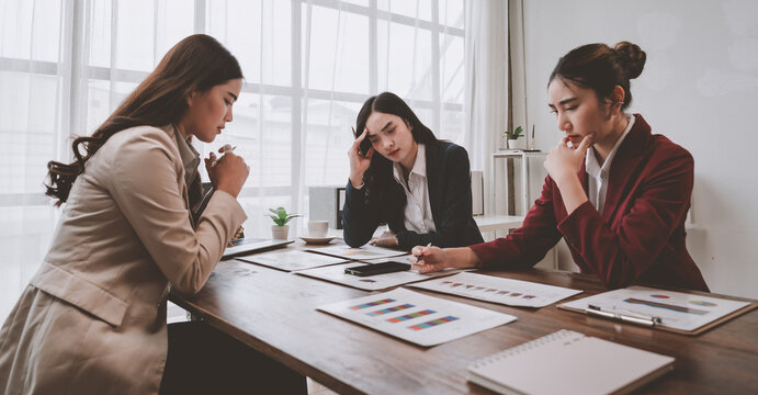 Businesswomen analyzing financial reports and brainstorming solutions - Powered by Adobe