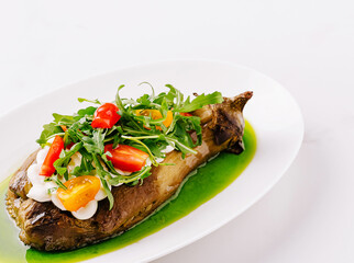Delicious grilled eggplant with fresh vegetables and sauce on plate