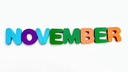 Wooden letters spelling out 'November' on a white background.