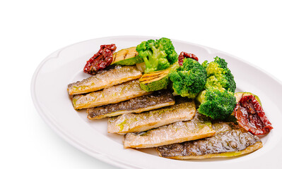 Grilled fish with steamed broccoli and sun-dried tomatoes on a plate