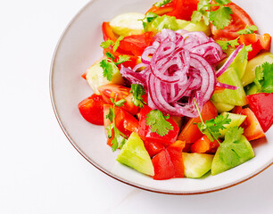 Fresh vegetable salad with cucumber, tomatoes, and red onion garnished