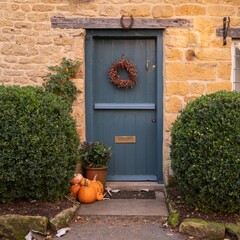 Naklejka premium Cotswold cottage door with pumpkins, England
