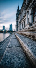 Fototapeta premium Stone steps leading to a grand building by a river at twilight