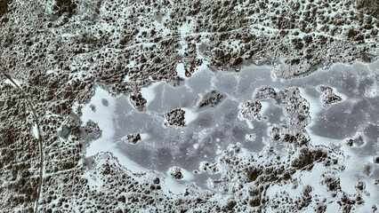 Aerial View of Snow Covered Landscape with Frozen Water Body