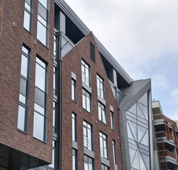 Modern brick house with large glass windows against a clear blue sky. The Gothic style.