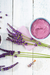 cosmetic cream, soap and purple lavender flowers on white wooden, top view