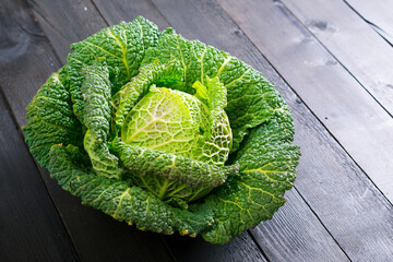 Fototapeta premium savoy cabbage from organic grower farm, on black wooden table