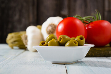 fresh tomato, garlic, olive, uncooked tagliatelle pasta on white wooden