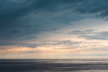 Offshore wind turbines under dramatic cloudy sky on the North Sea coast of the Netherlands