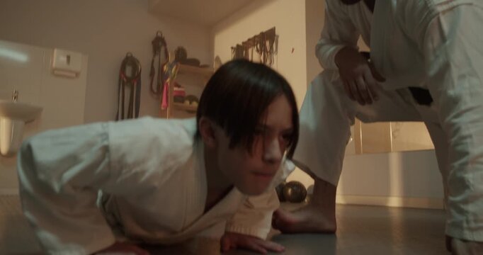 Karate student does push ups under martial arts master control