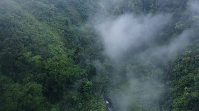 An awe-inspiring aerial shot of Catarata del Toro river in Costa Rica ending over the cloudy Mountains.
