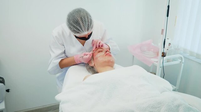 Woman addressing pigmentation issues on girl face. Female professional performing dermatological procedures. Girl undergoing cosmetology treatment for improved skin tone and health