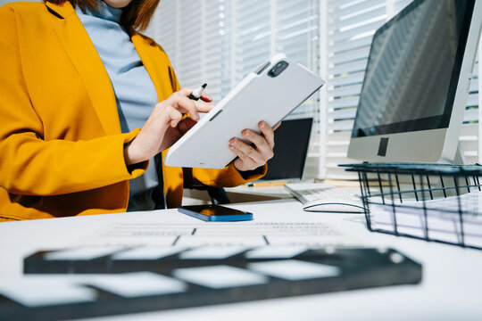 Creative woman using clapperboard in modern office studio, perfect for film production, video content, and cinematic storytelling concepts.