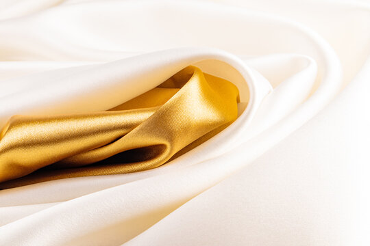Luxurious satin fabric in gold and ivory shades
